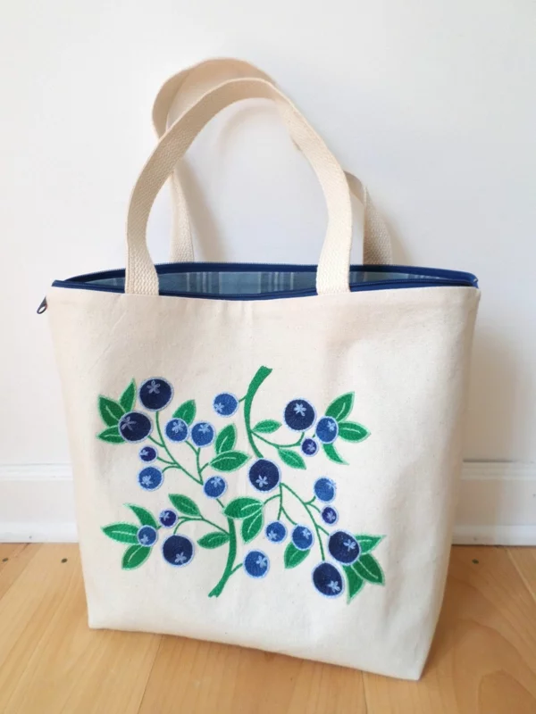 Jutebeutel bemalen eine Handtasche mit grünen Blättern und blauen Blumen verzieren
