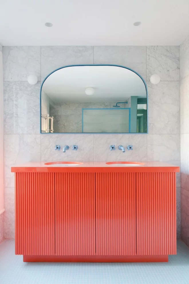 Mid-Century Modern Wohnstil Bad graue Fliesen in Marmor Optik Korallenfarbe Waschtisch großer Spiegel