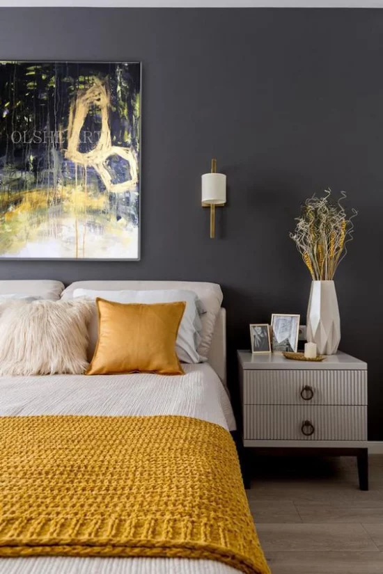 Schlafzimmer Ideen in Grau und Gelb graphitgraue Wand dunkler Hintergrund Wandbild gelb gestrickte Bettdecke