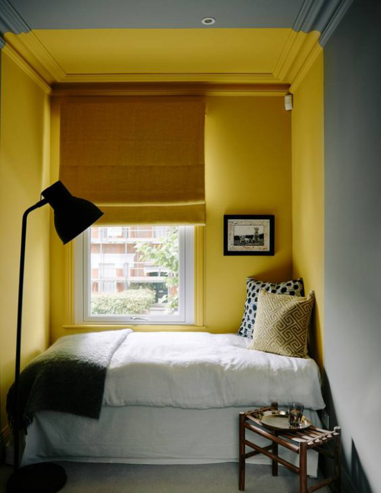 Schlafzimmer Ideen in Grau und Gelb kleines Zimmer Bett vor dem Fenster gelbe Wand gelbe Rollos weiße Bettwäsche