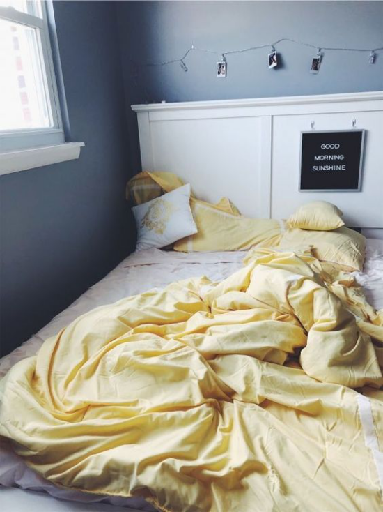 Schlafzimmer Ideen in Grau und Gelb ungemachtes Bett weiße Bettwäsche hellgelbe Decke dunkelgraue Wände Fenster