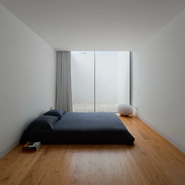 Schlafzimmer minimalistisch einrichten großes Deckenhohes Fenster graue Wände schwarzes Schlafbett Boden aus hellem Holz