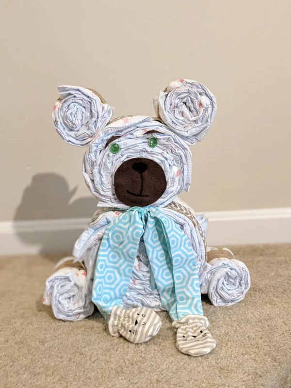 Kuscheltier aus Windeln Hund basteln mit blauer Schleife dekorieren schönes Geschenk für die Babyparty