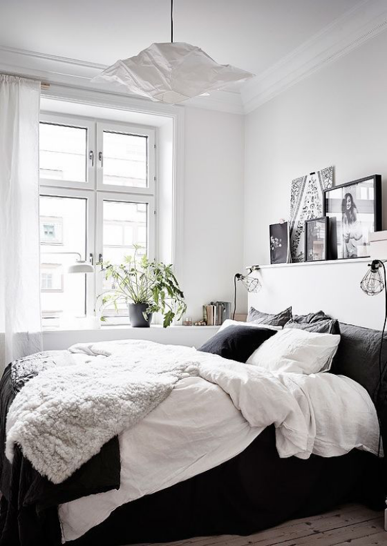 kleines Schlafzimmer einfaches Raumdesign bequemes Bett visueller Kontrast zwischen Weiß und Schwarz
