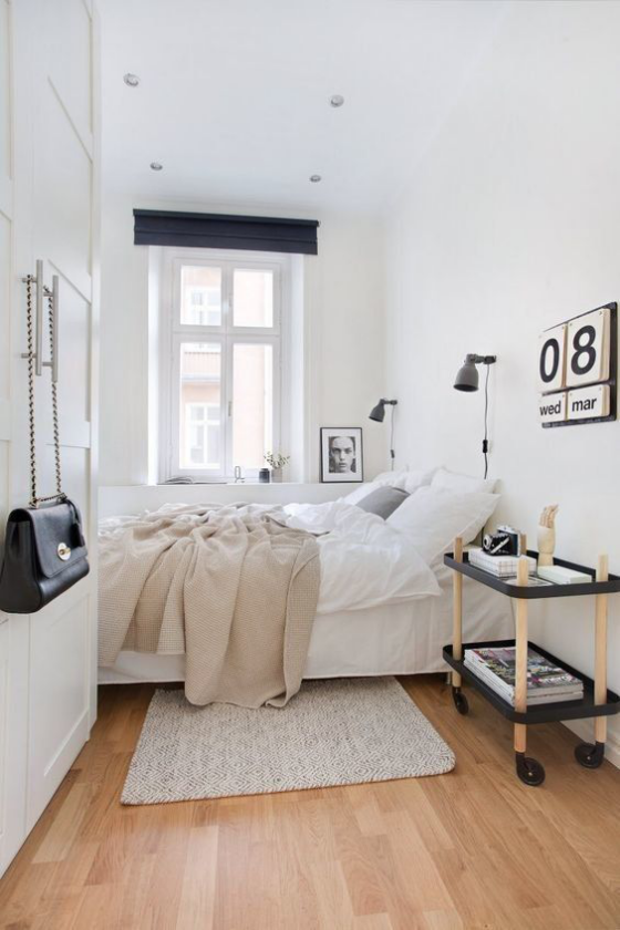 kleines Schlafzimmer einfaches skandinavisches Design Weiß dominiert Tisch auf Rollen Kalender an der Wand