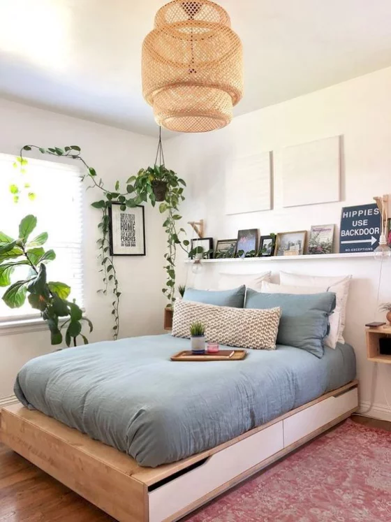 kleines Schlafzimmer schönes Raumdesign Bett aus Holz Schubladen gute Stauraummöglichkeit blaue Bettwäsche sehr einladend wirken