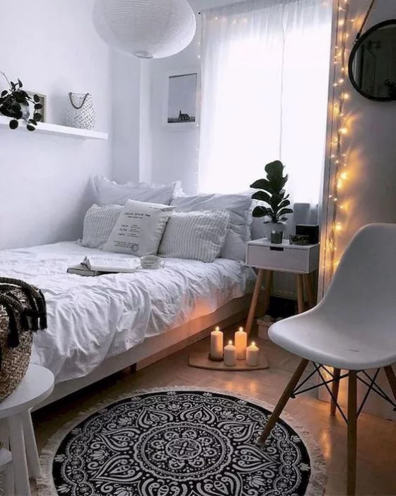 kleines Schlafzimmer schönes Raumdesign Lichterketten an der Wand Kerzen vor dem Bett romantische Atmosphäre