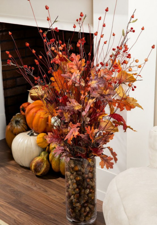Deko Ideen mit Herbstblättern Glas mit bunten Blättern Kürbisse im Hintergrund