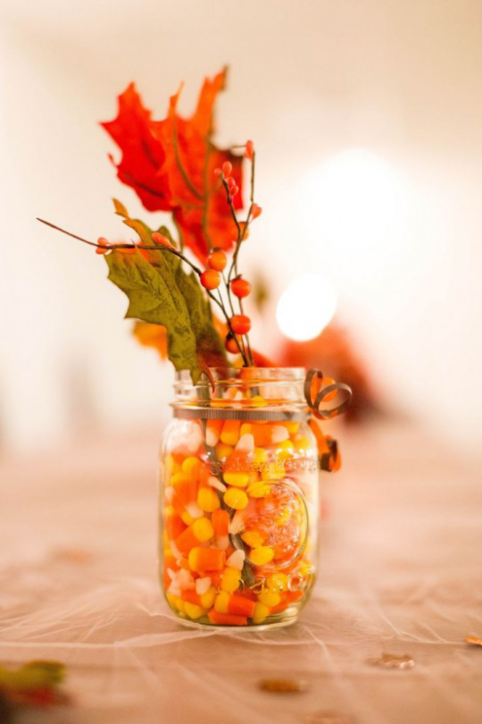 Deko Ideen mit Herbstblättern Glas voll mit Maiskörnern Zweig Beeren zwei bunte Blätter