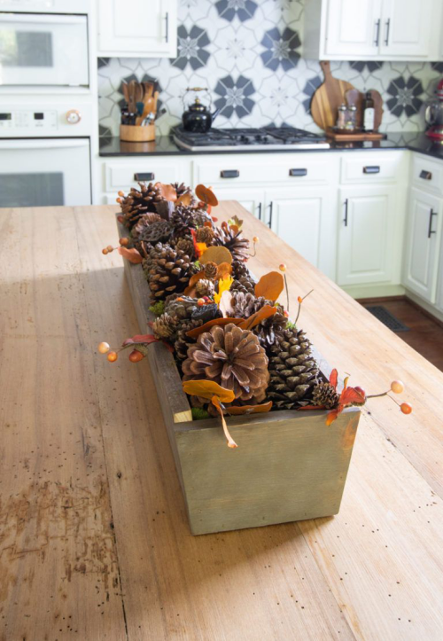 Herbstdeko mit Tannenzapfen Holzkasten in der Tischmitte voll mit Zapfen Herbstblätter Waldbeeren