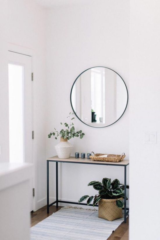 Eingangsbereich modern gestalten einfache Flurmöbel Tisch Grünpflanze weiße Vase mit grünen Zweigen heller Teppich runder Spiegel