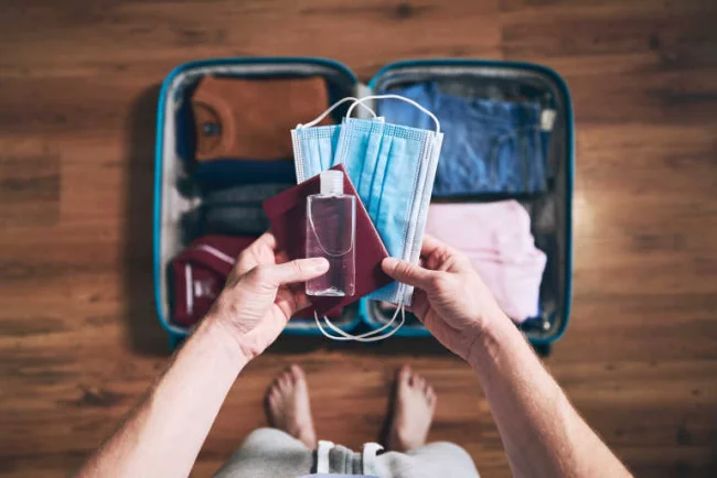 Fliegen während Corona wenig Gepäck mitnehmen Reisepass Mundschutzmasken Desinfektionsmittel nicht vergesse