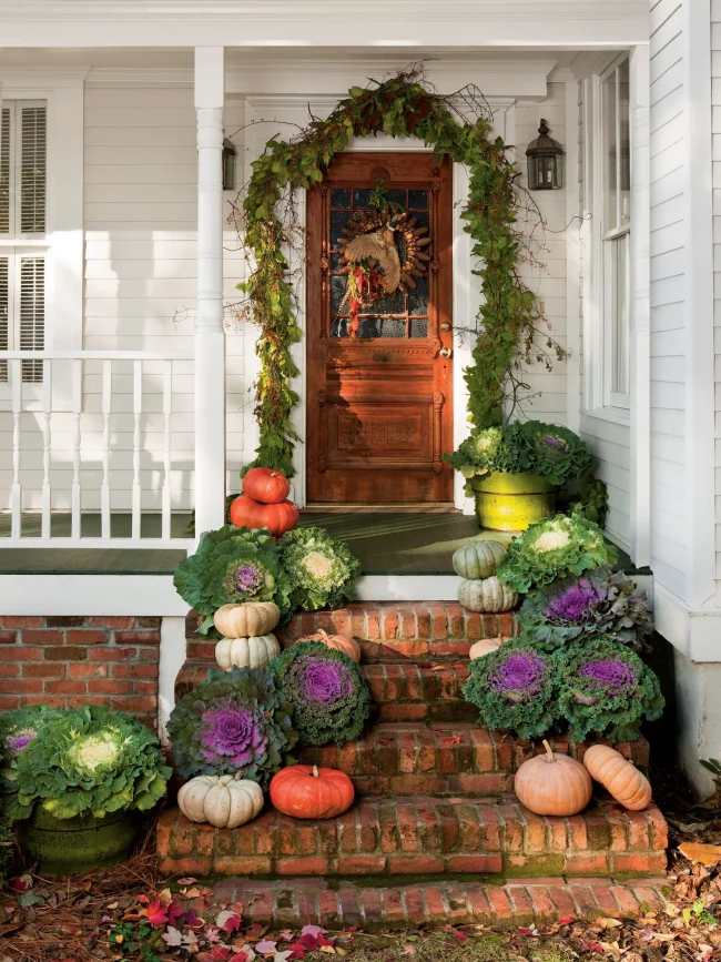 Herbstdeko für draußen Zierkraut Kürbisse auf den Treppen vor der Haustür arrangiert