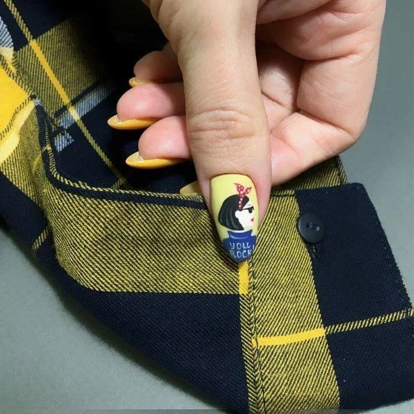 lustiges Muster eines Frauengesichts auf den gelben Nägeln