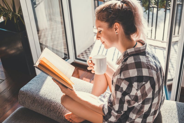 Sternzeichen gern alleine unabhängige Einzelgänger junges Mädchen zu Hause Kaffee trinken ein Buch lesen
