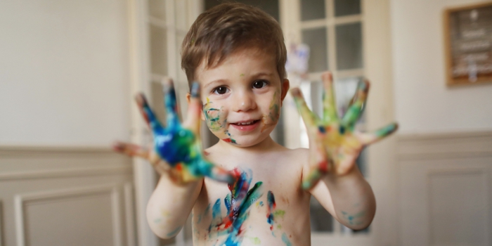 A 2 years old boy doing painting at home