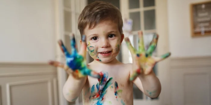A 2 years old boy doing painting at home