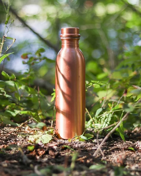 eine Kupferflasche auf dem Boden im Garten 