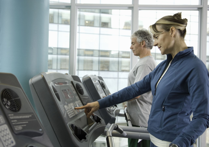 Abnehmen im Alter Mann Frau im Fitnessstudio Training an Geräten