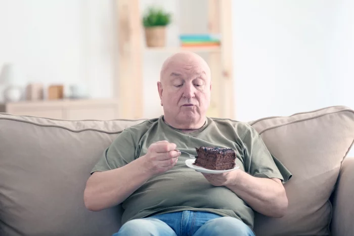 Abnehmen im Alter Senior ein großes Stück Torte essen lieber darauf verzichten