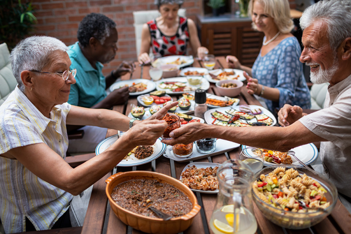 Abnehmen im Alter Senioren beim gemeinsamen Essen gute Kontakte pflegen sprechen lachen zusammen
