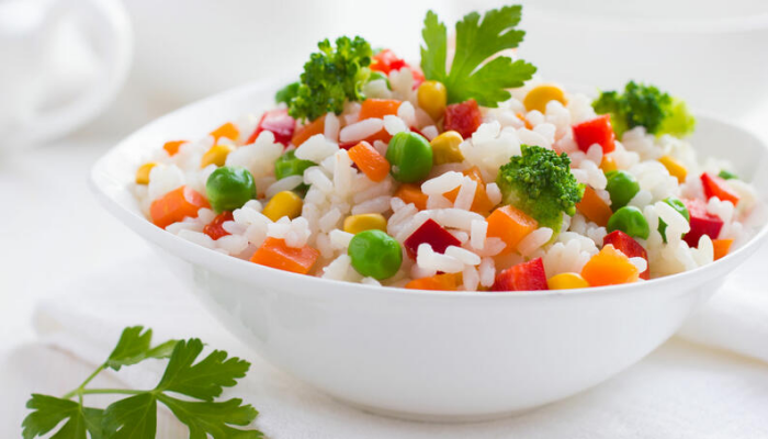 Reisdiät gekochter Reis mit Gemüse in einer weißen Schale schmeckt gut ist gesund