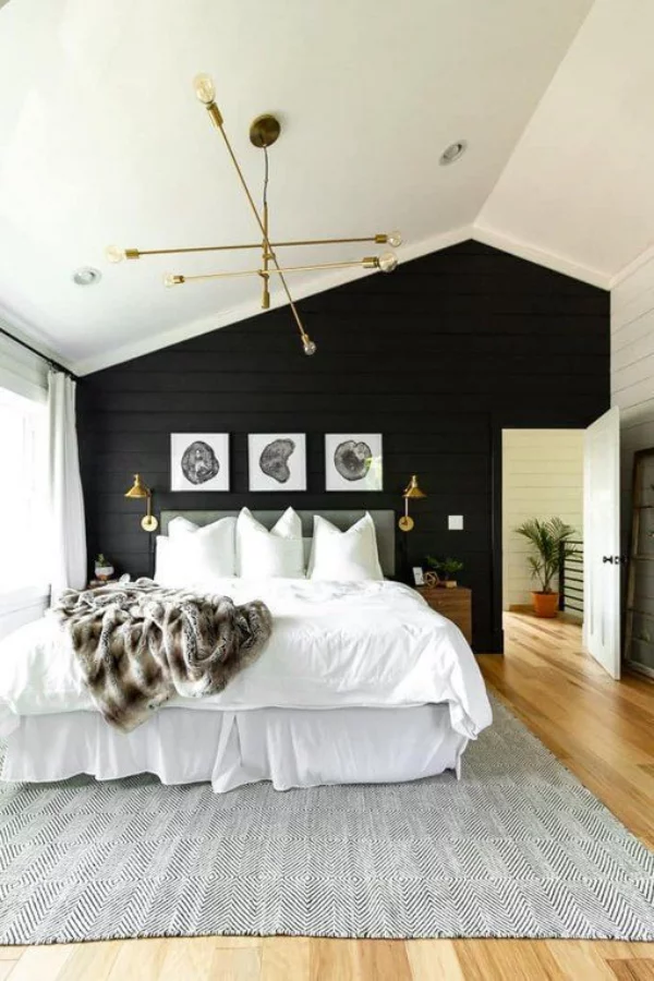 Schwarze Wand im Schlafzimmer asymmetrisch hinter dem Schlafbett drei Bilder Wandlampen schicke Raumgestaltung