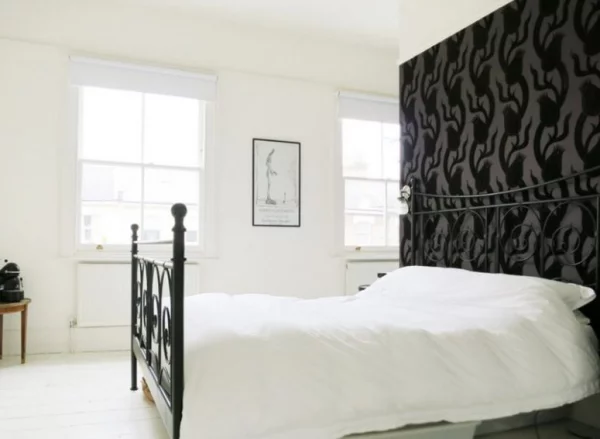 Schwarze Wand im Schlafzimmer gemustert nicht ganz schwarz wei0e Bettwäsche als Kontrast