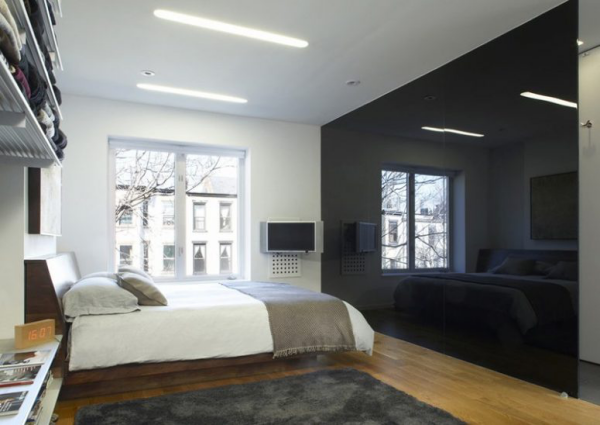 Schwarze Wand in Hochglanz als Akzent ein geräumiges Schlafzimmer Weiß und Grau