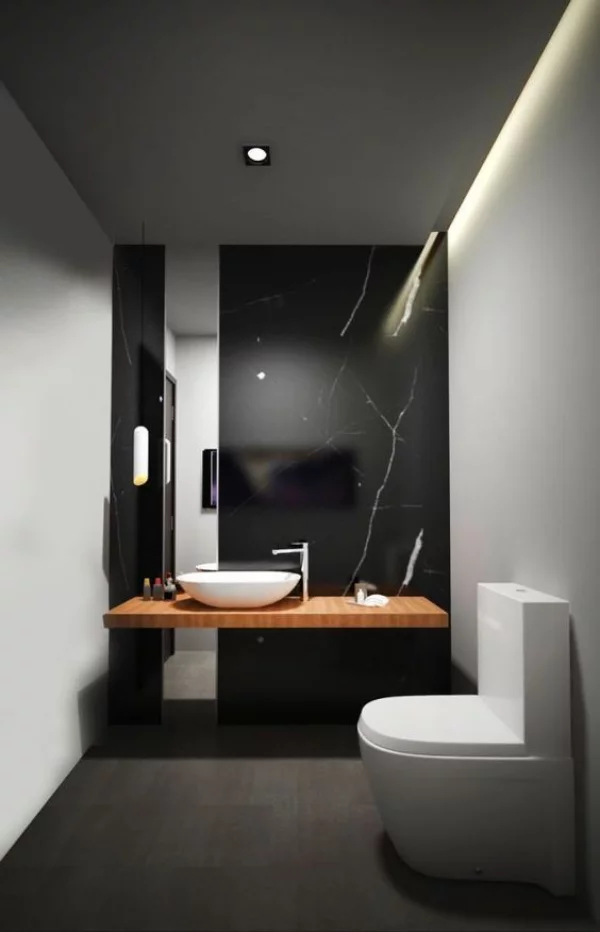 Schwarze Wand modernes Bad WC Akzentwand aus schwarzem Marmor Bodenfliesen in Anthrazit weißes Waschbecken Waschtisch aus Holz