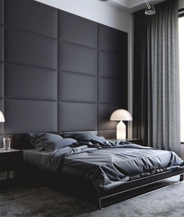 Schwarze Wand stilvoll eingerichtetes Schlafzimmer mit schwarzem Leder gepolsterte Akzentwand hinter dem Schlafbett graue Gardinen Bettwäsche grauer Teppich