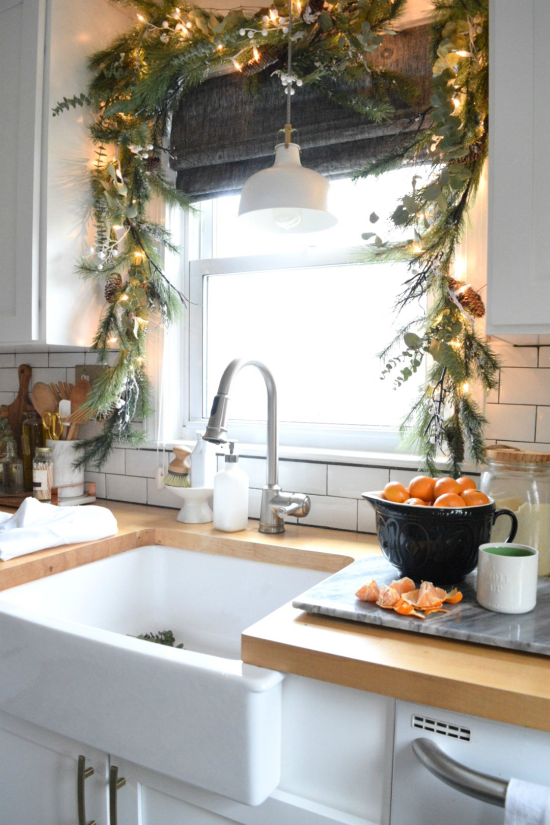 Weihnachtliche Fensterdeko Girlande am Küchenfenster Tannengrün glitzernde Kugeln LED Lichter