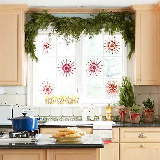 Weihnachtliche Fensterdeko Girlande aus Tannengrün am Küchenfenster hängende Sterne