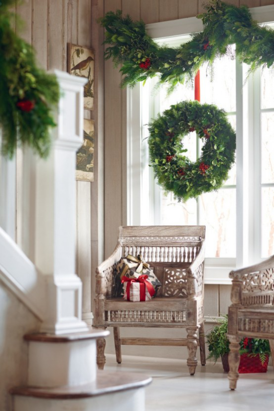 Weihnachtliche Fensterdeko Kranz Girlanden aus Tannengrün rote Schleifen sehr attraktiv am Fenster