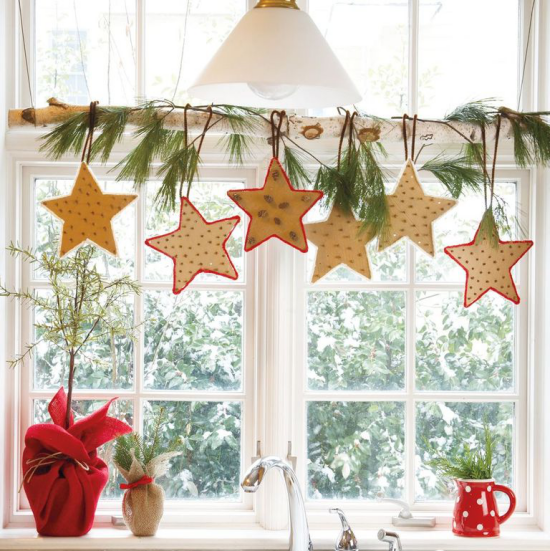 Weihnachtliche Fensterdeko Küchenfenster schmücken Birkenast bunte Sterne aufgehängt Tannengrün dazu