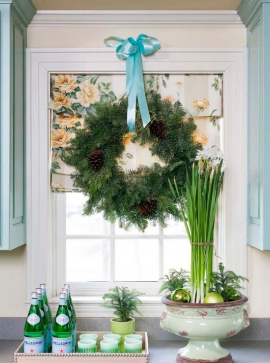 Weihnachtliche Fensterdeko großer Kranz aus Tannengrün Zapfen blaue Schleife am Küchenfenster