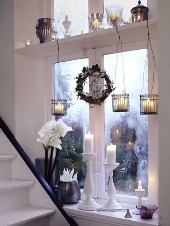 Weihnachtliche Fensterdeko schöner Fensterschmuck von draußen zu sehen Vase mit weißen Blumen drei weiße Kerzen hängende Teelichter kleiner Kranz