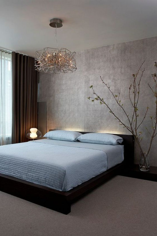 Zen Schlafzimmer schönes Raumdesign, hellblaues Bettlaken dezentes Licht hinter dem Bett Nachttischlampe blühende Zweige