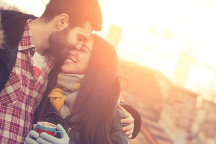 gesund und glücklich im Winter bleiben junges Paar kuschelt lacht trotz der Kälte