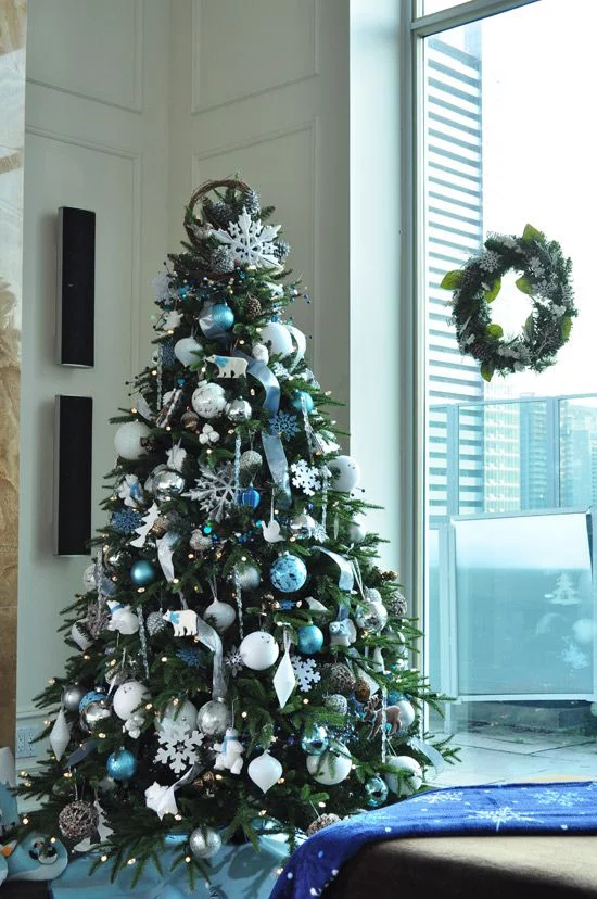 Blau und Silber Weihnachten und Silvester feiern Christbaum geschmückt neben dem Fenster Kranz an der Glasscheibe
