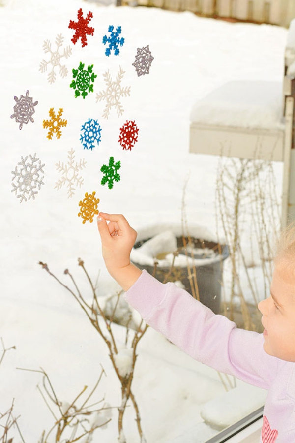 Fensterbilder basteln zu Weihnachten – zauberhafte Ideen und Anleitungen kinder spielen mit schneeflocken bilder