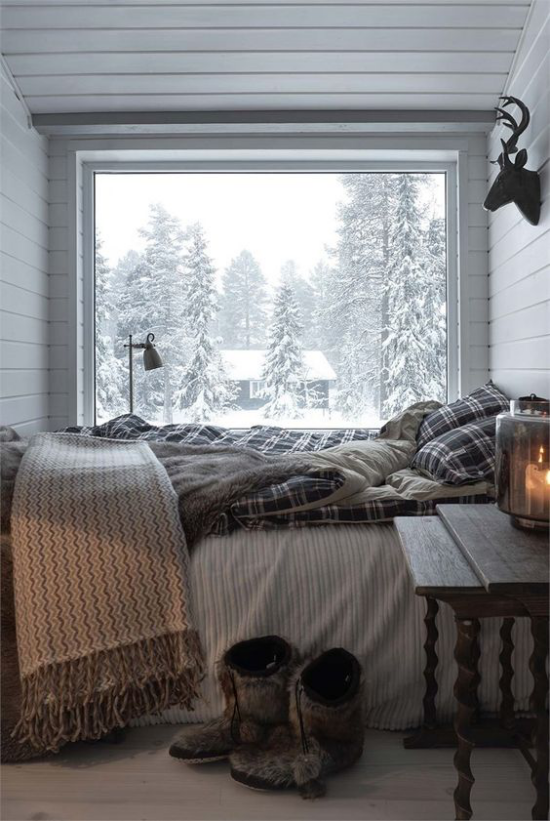 Glaswände im Schlafzimmer kleiner Schlafbereich Bett vor dem Fenster Winterlandschaft draußen