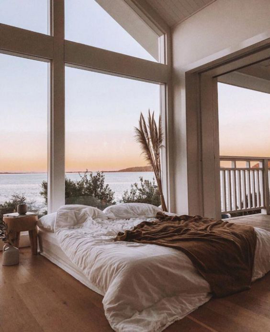 Glaswände im Schlafzimmer romantische Aussicht Meer Schlafbereich in warmen Farben