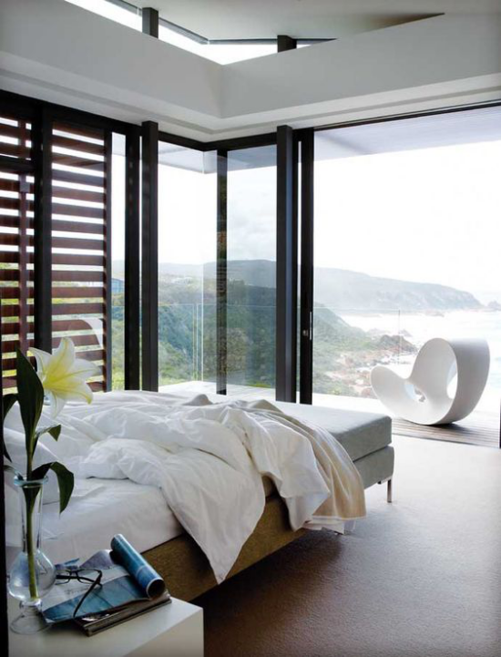 Glaswände im Schlafzimmer schickes Schlafzimmer an der der Küste Holzrollos Panoramablick