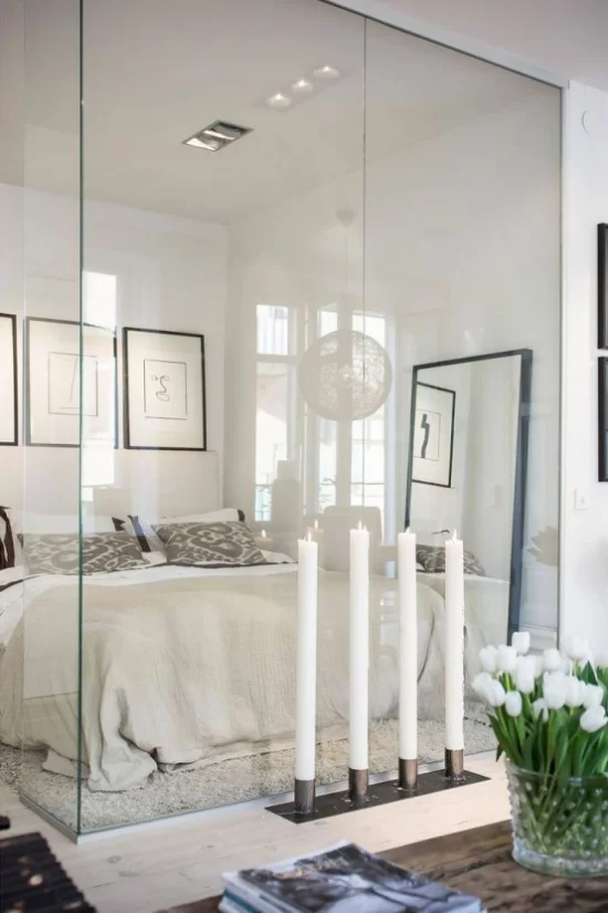 Glaswände im Schlafzimmer vier große weiße Kerzen künstliches Licht ausgefallene Raumgestaltung