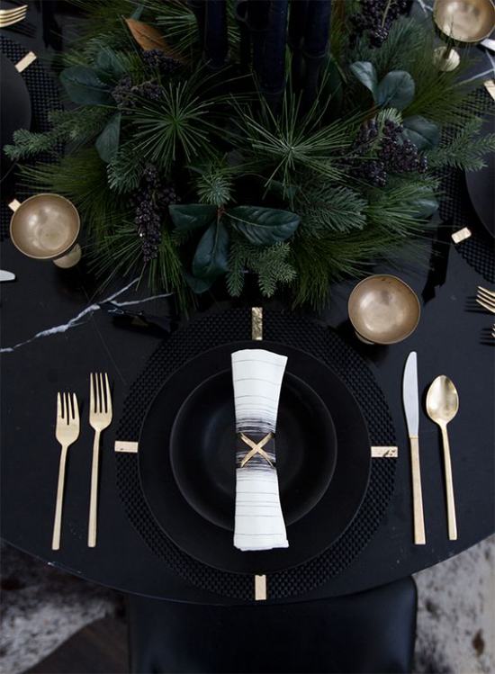 Silvester feiern zu Hause festlich gedeckter Tisch schwarze Tischdecke schwarzes Service goldglitzerndes Besteck etwas Grün in der Tischmitte