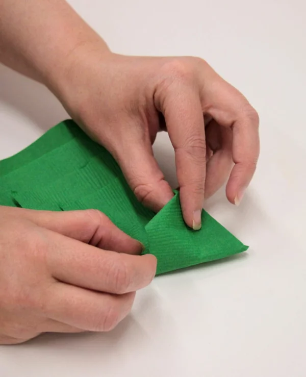 grüne Papierserviette falten zu Tannenbaum Serviette genaue Anleitung Schritt 6