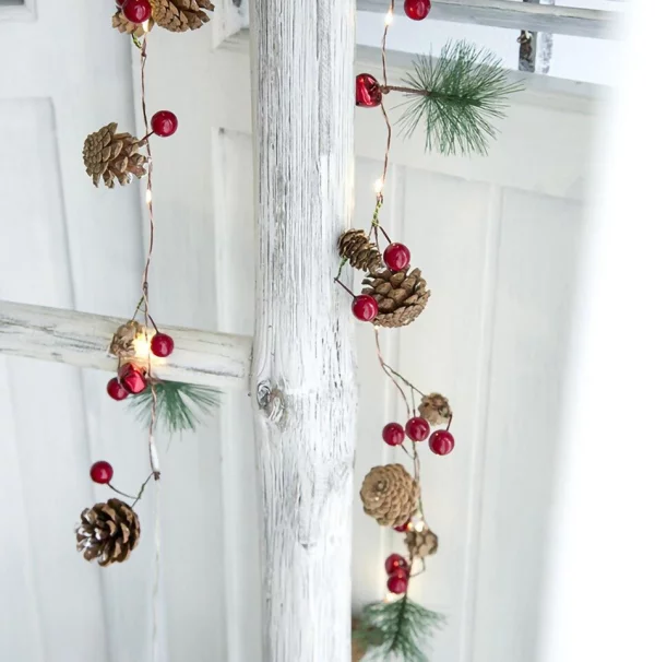 Tannenzapfen Winterdeko winterliche Lichterkette tolle Dekoidee rustikal an einer Holzleiter hängend