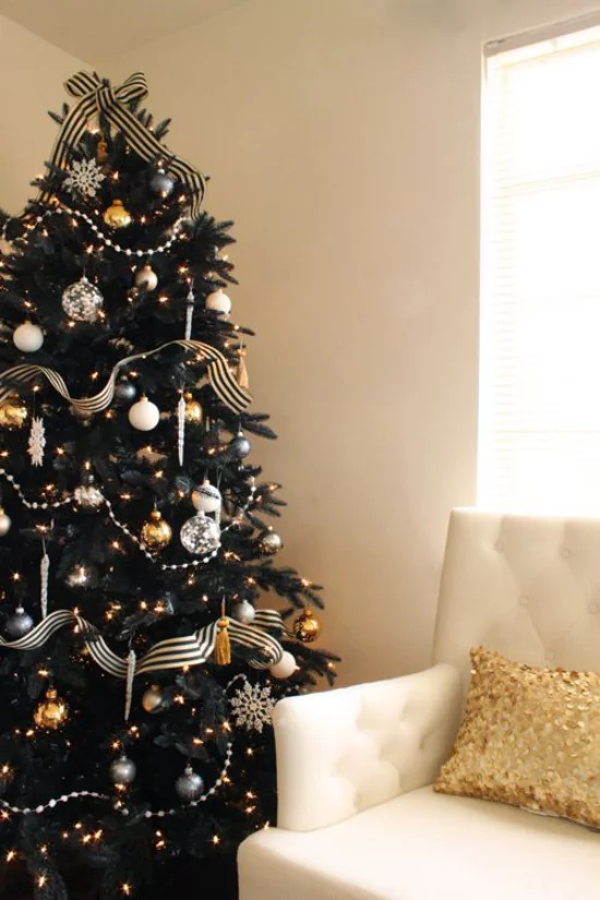 Weihnachtsdeko in Gold und Schwarz dunkelgrüner Tannenbaum perfekter Hintergrund für goldgelbe und silberne Ornamente