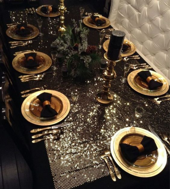Weihnachtsdeko in Gold und Schwarz festlich gedeckter Esstisch sehr spektakulär glitzernde Tischdecke goldenes Geschirr schwarze Servietten